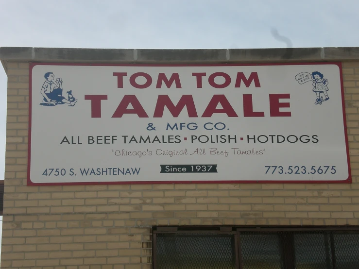 a sign on the side of a building stating it is too  for tamale