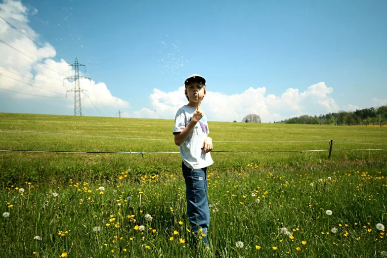 a boy stands in the grass with his frisbee