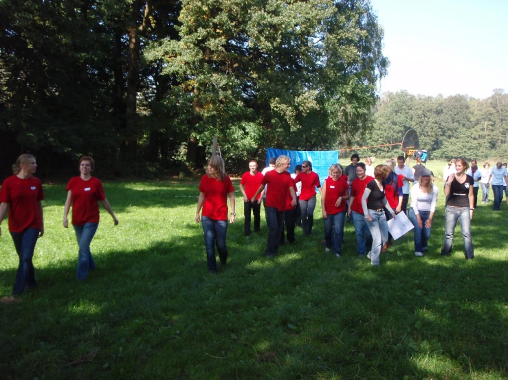 people in red shirts are in the middle of a field