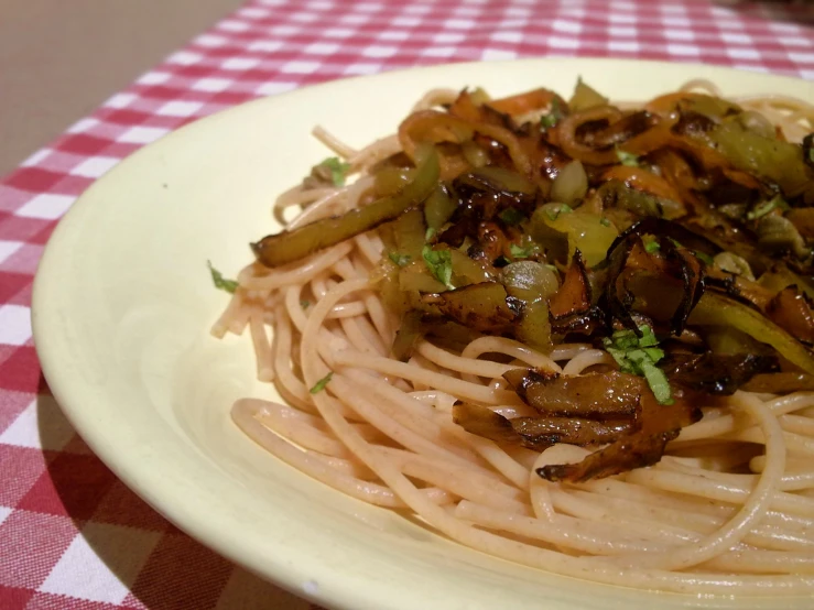 a white plate topped with pasta and meat covered in sauce