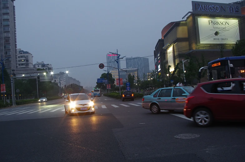 several cars and buses driving down an empty street