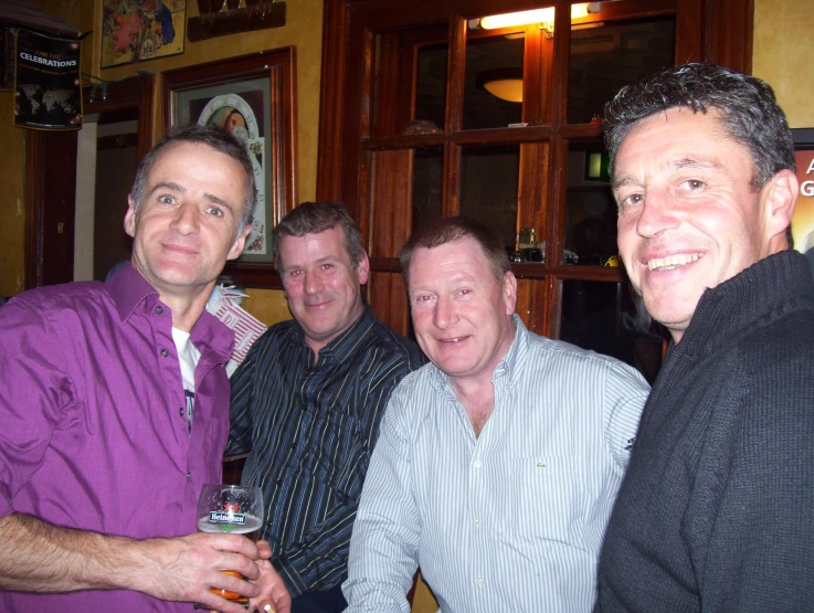 a group of men holding up glasses of wine