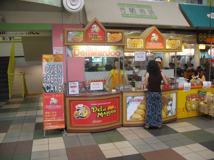 a lady looking at the food stand in a mall