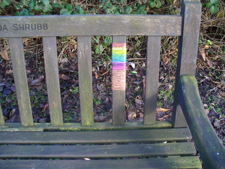 a wooden bench with a piece of yarn wrapped around the back