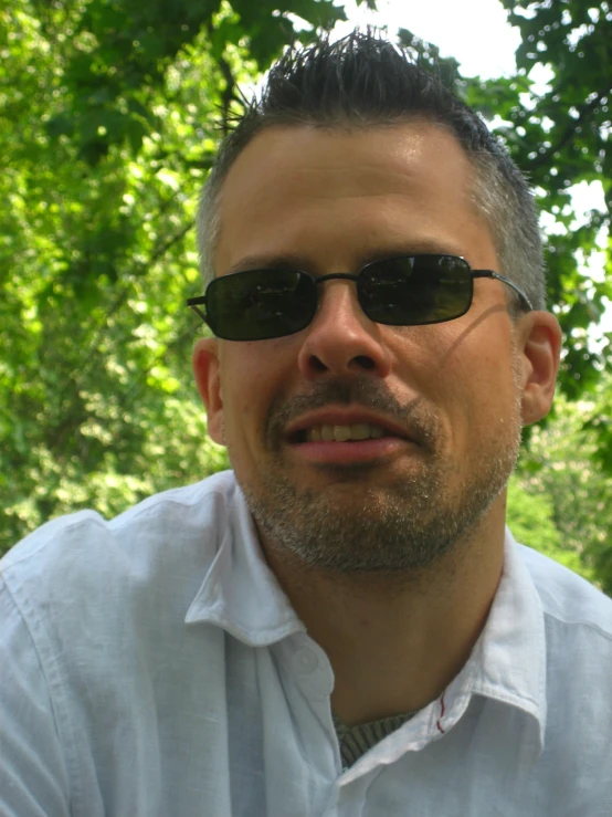 a man is wearing sunglasses and looking at the camera