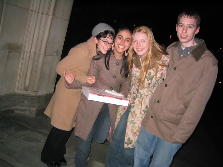 three women and a man smiling for the camera