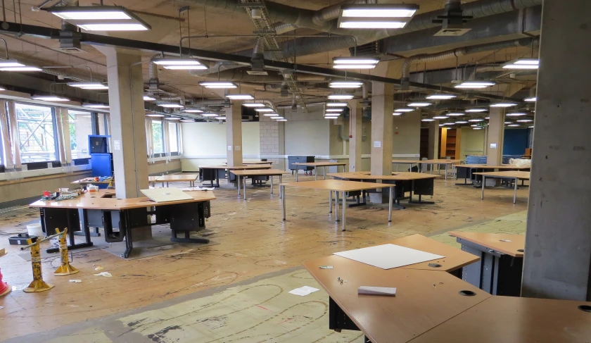 an empty classroom is shown with many desks in it