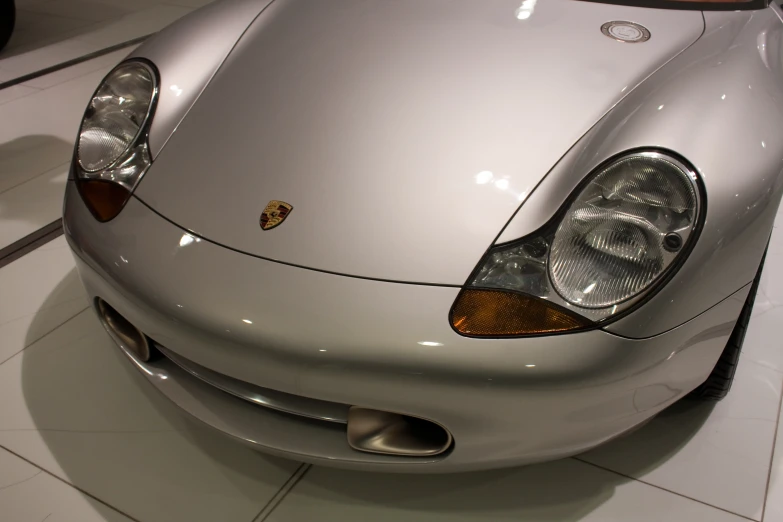 a metallic sports car sits on a tiled floor