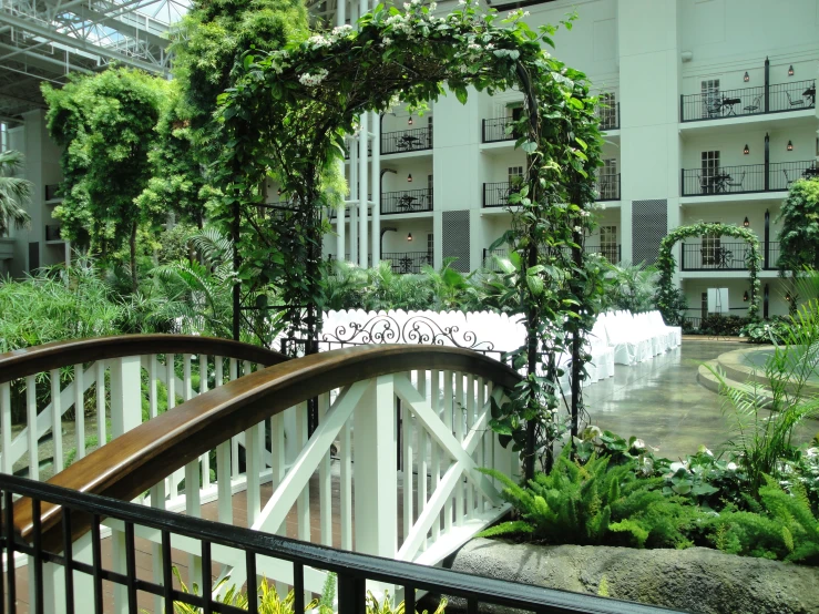 a wooden bridge crosses the pathway at an all white courtyard