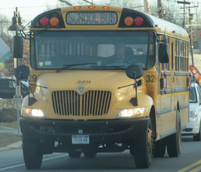 two school buses traveling down a road next to each other