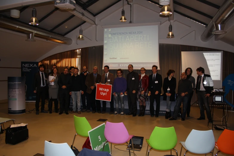 people gathered together in front of a projector screen with a large screen