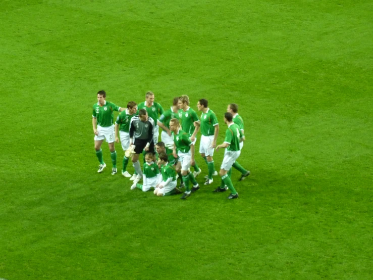 a group of men standing around a soccer field