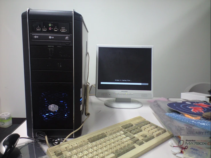 an older desktop computer is on the desk near a keyboard