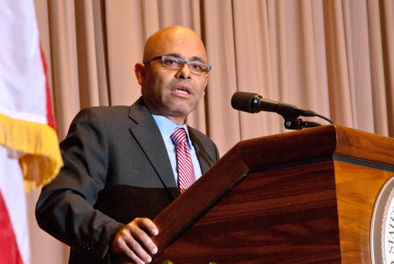 a man speaking at a podium during an event