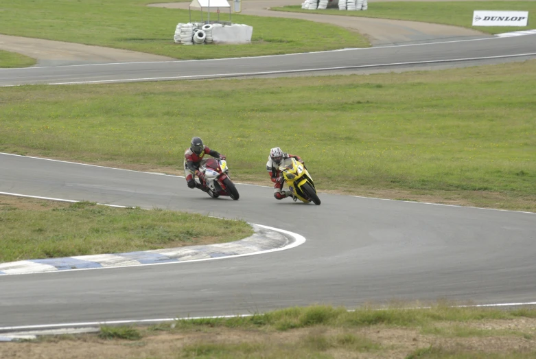 two people on motorcycles are racing around the track