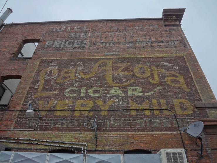 a brick building with a large yellow and red sign on the side