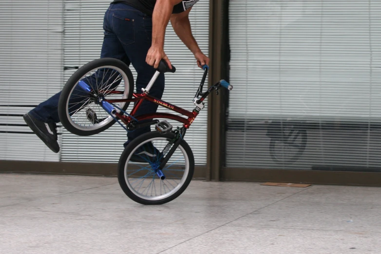 a person doing a trick on a bike over another bicycle