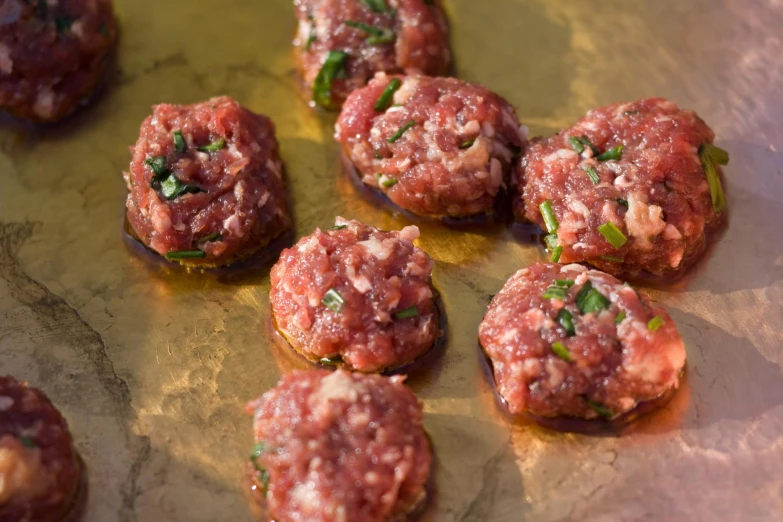 a pan full of small hamburgers sitting on a pan