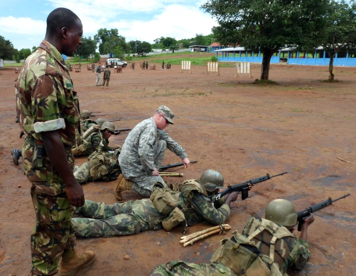 a soldier and another soldier with guns talking to another person