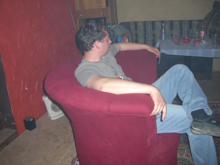 a young man sitting on top of a purple chair