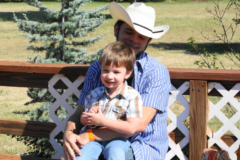 a  sits on the bench while his dad smiles