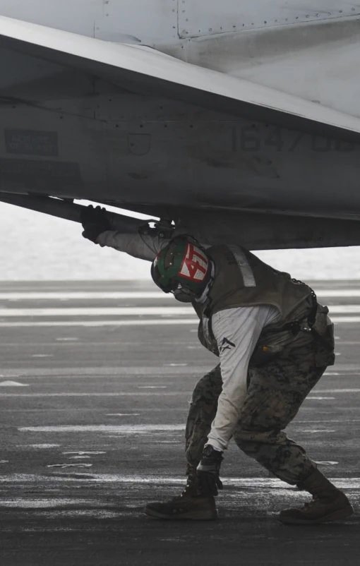 a person is standing under a airplane