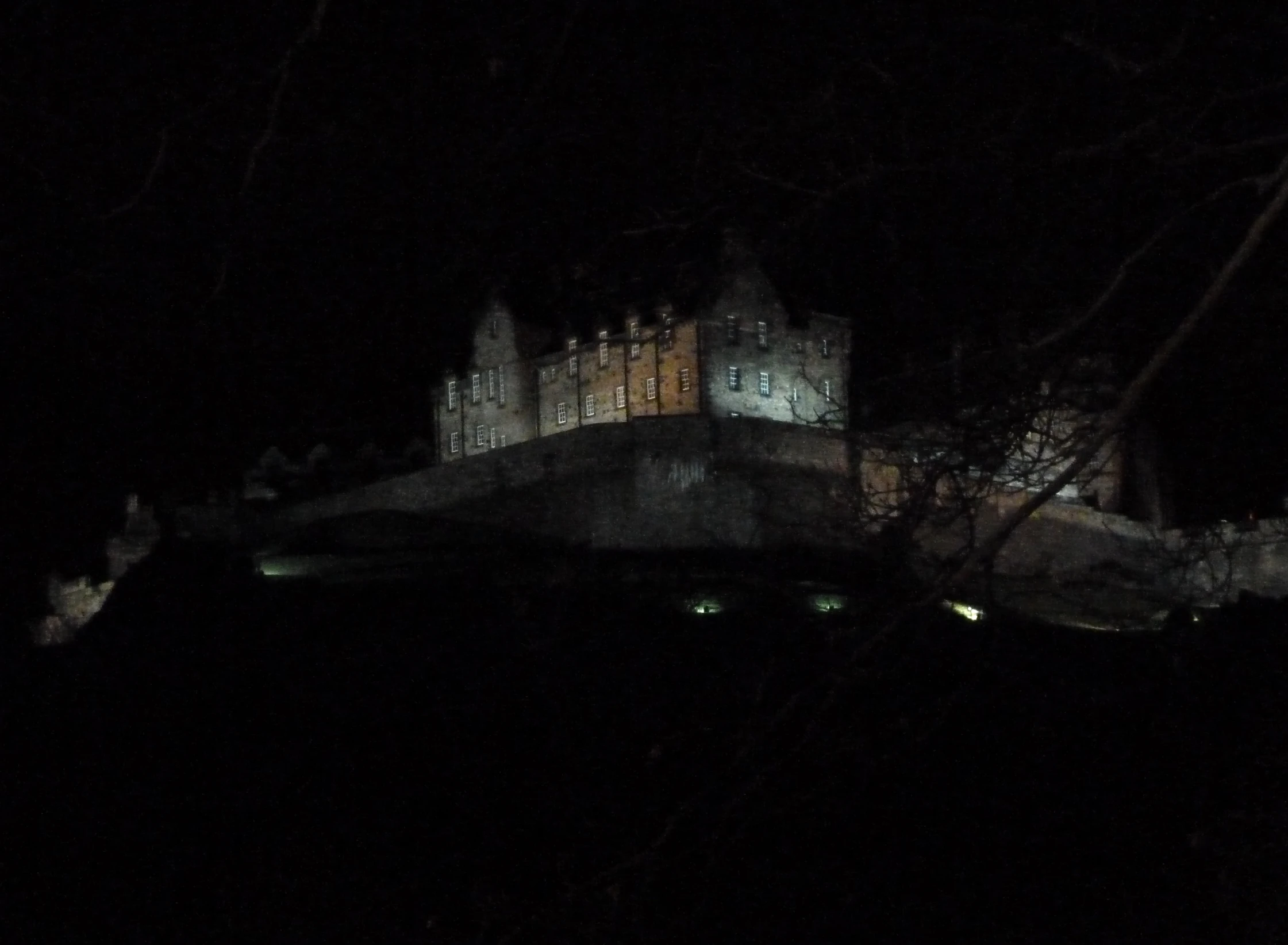 a castle lit up at night on top of a hill