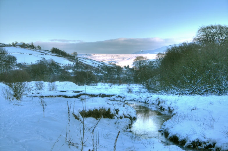 a mountain and stream in the snow near trees