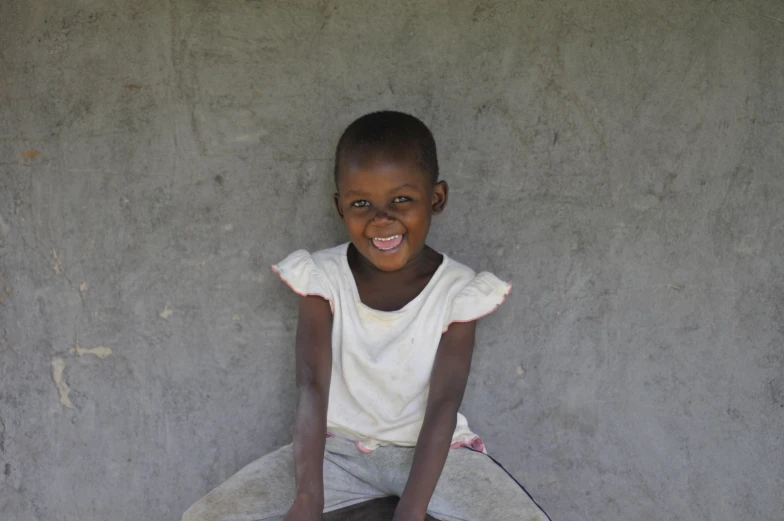 a young person sitting down smiling with their skateboard