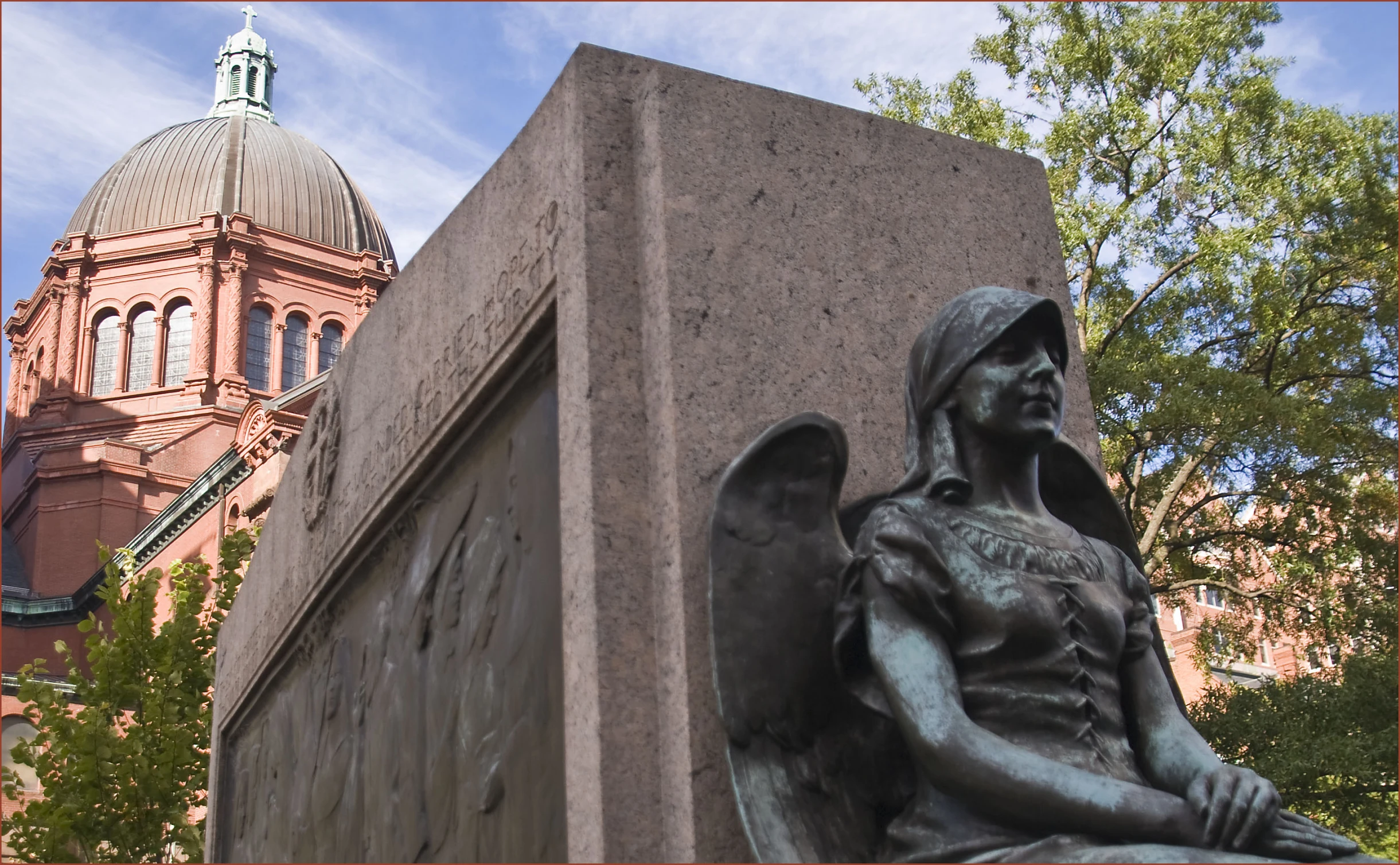 a statue in front of a monument next to a church