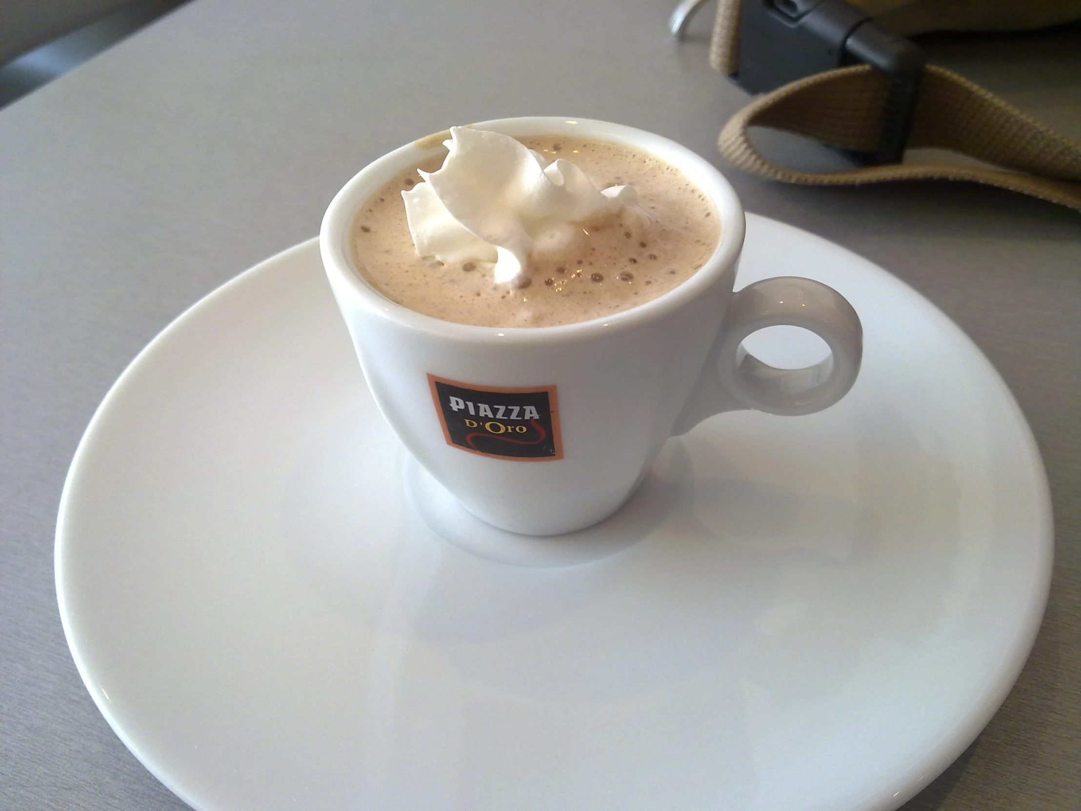 a cup of coffee on a white plate