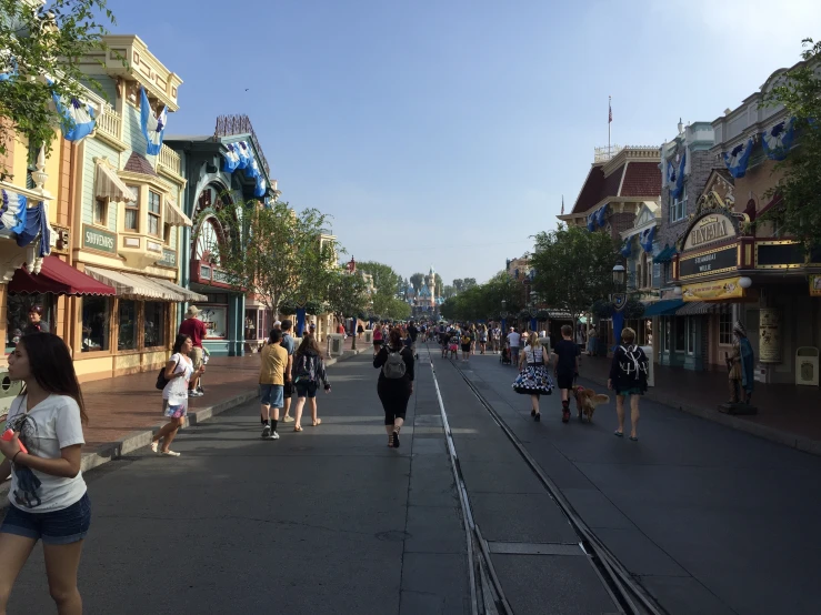 people are walking down a city street during the day