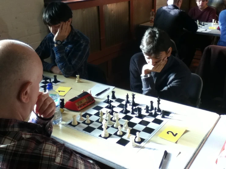 a chess game is being played by many people