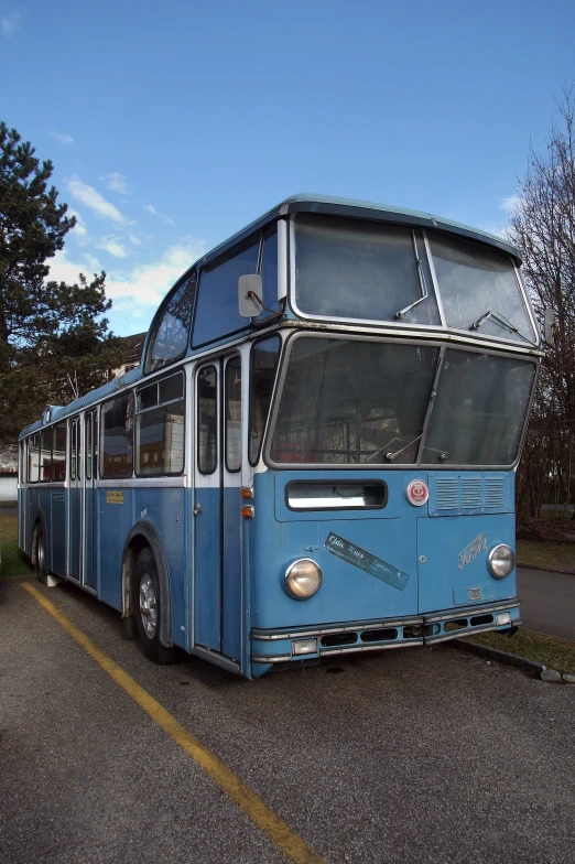 an old blue double decker bus parked in the middle of a parking lot