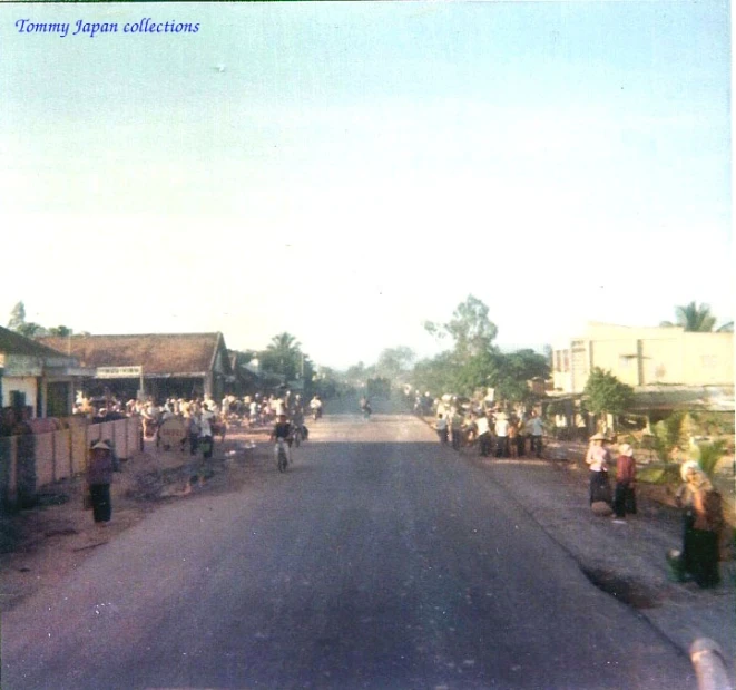 a large group of people gathered at the edge of a city street