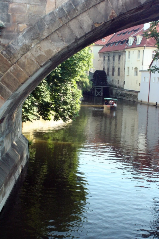 a boat in the water underneath a bridge near a building