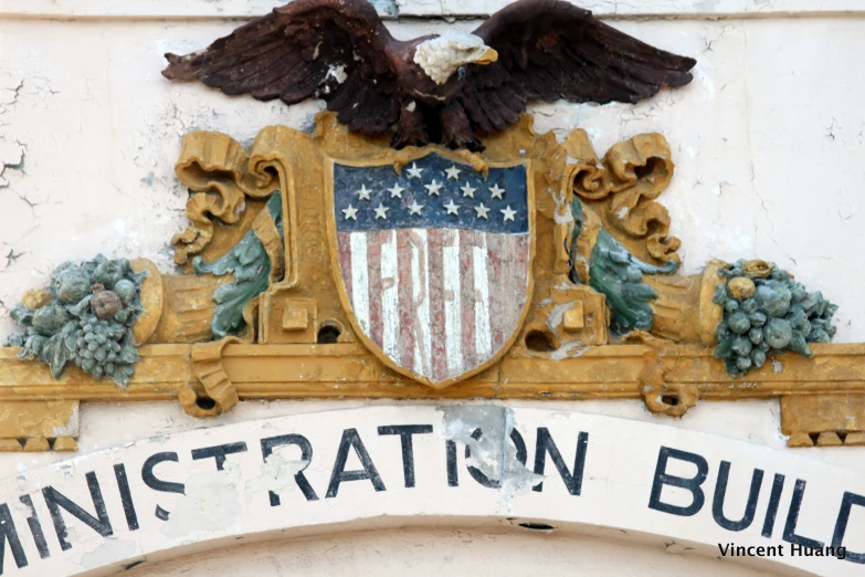 a patriotic sign hangs on a building and is decorated with an eagle, nch and g bush