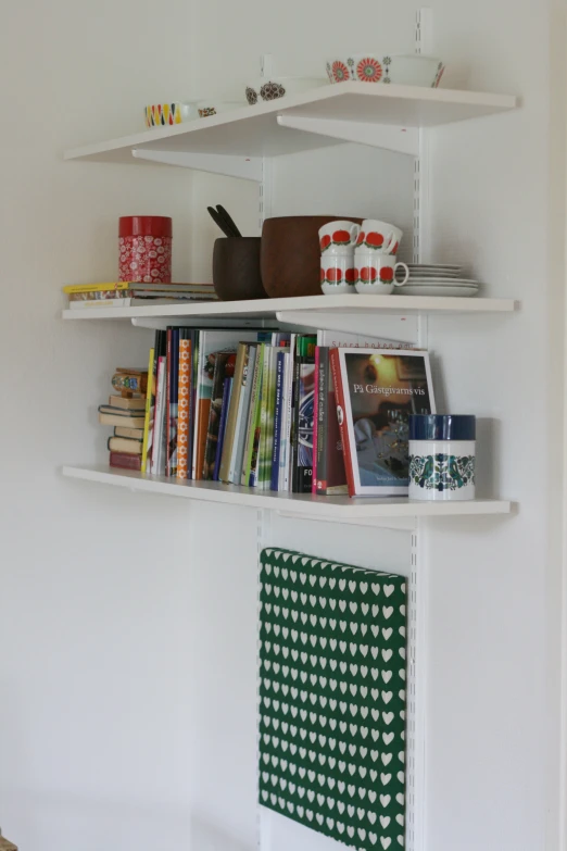 some shelves of books, magazines and other items on a wall
