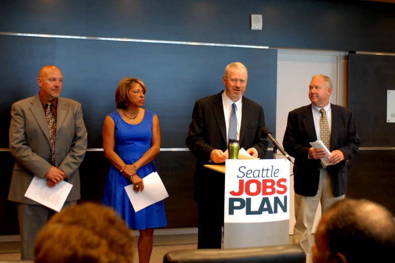 a group of people standing around a microphone