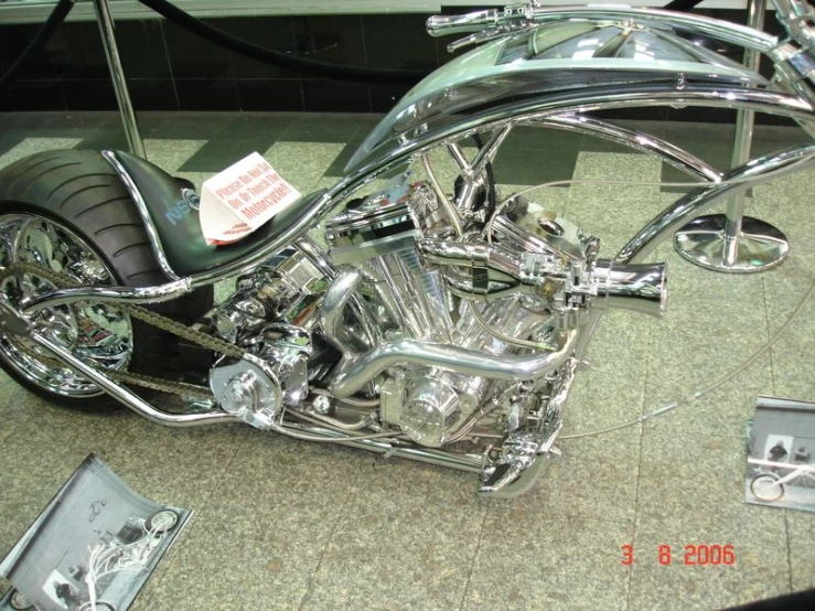 a shiny chrome motorcycle on display with a sign on it