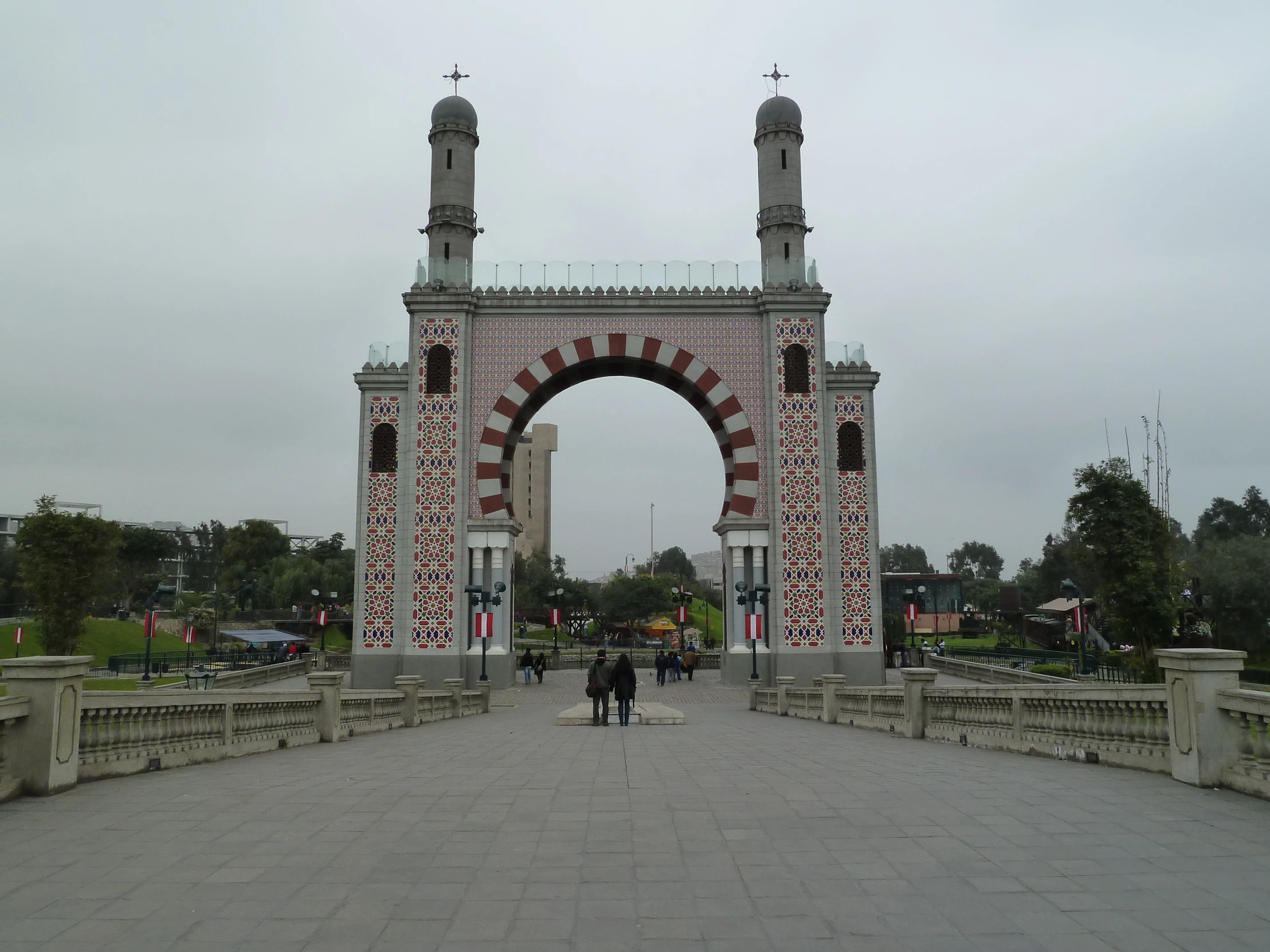 an ornate gate with people walking in front of it