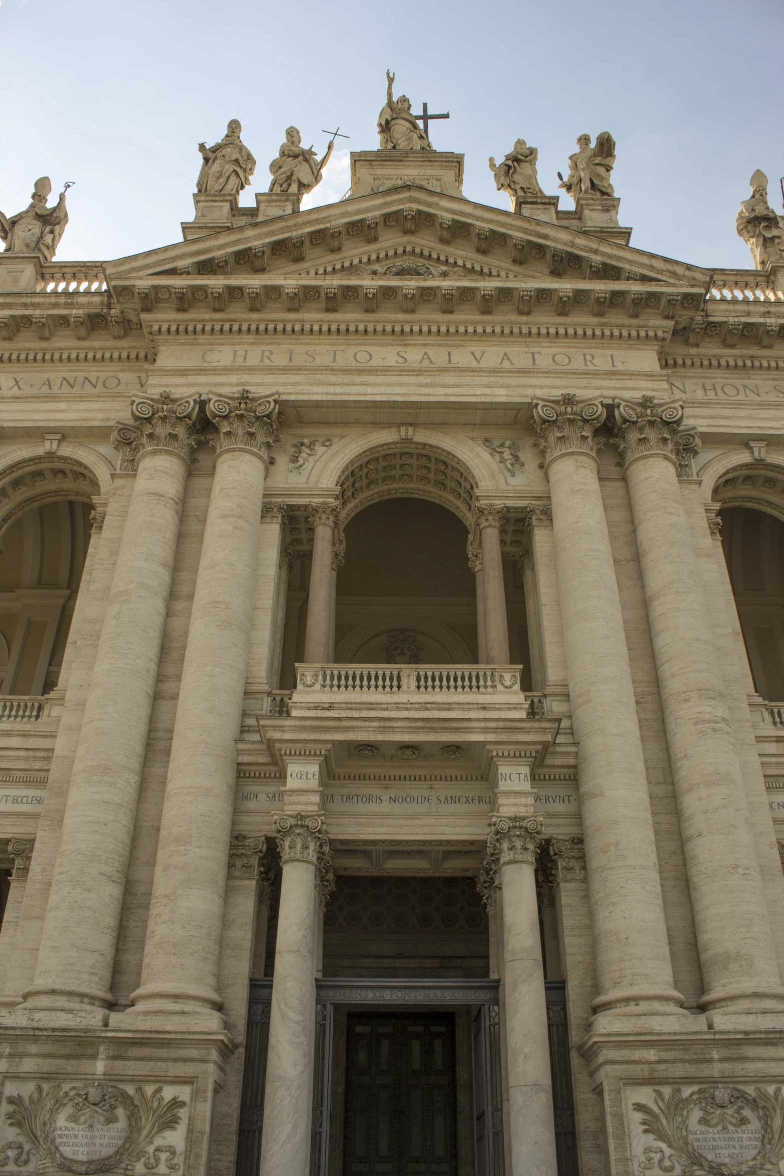 an entrance to a large, elegant building with three statues above it