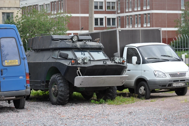 two military vehicles parked in front of a brick building