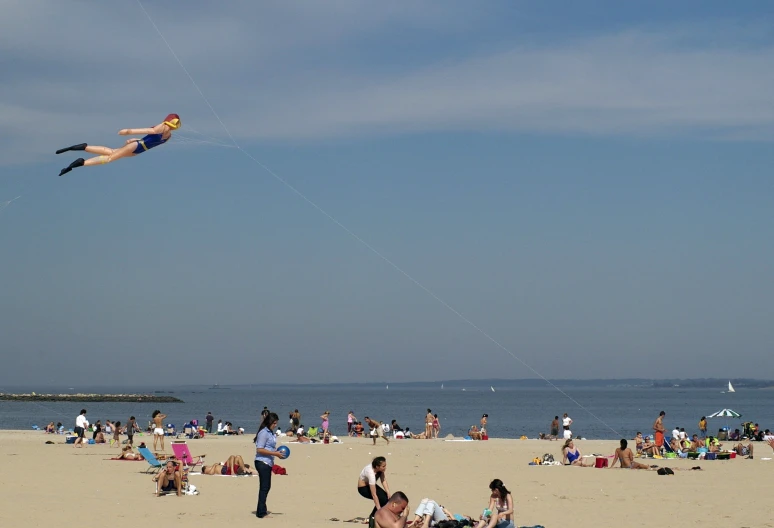 a woman flying a kite on top of a sandy beach