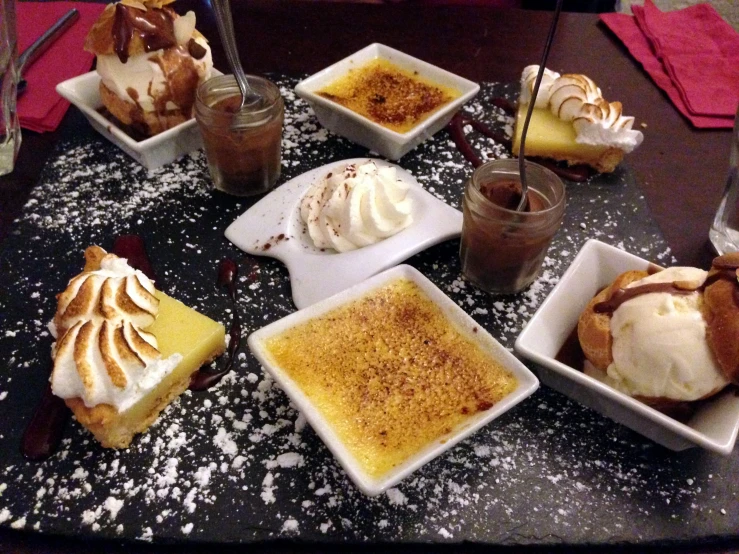 there are many desserts sitting on plates that have ice cream and other things