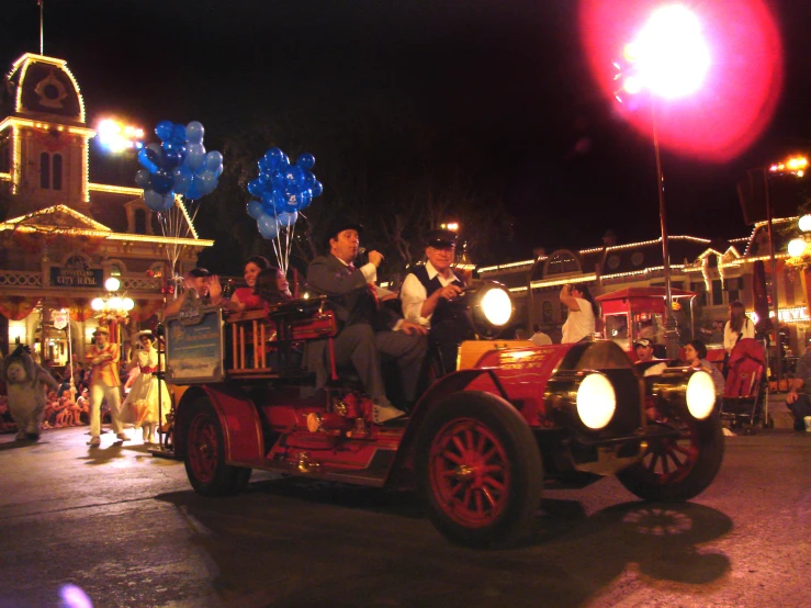 an old fashioned car driving down the street