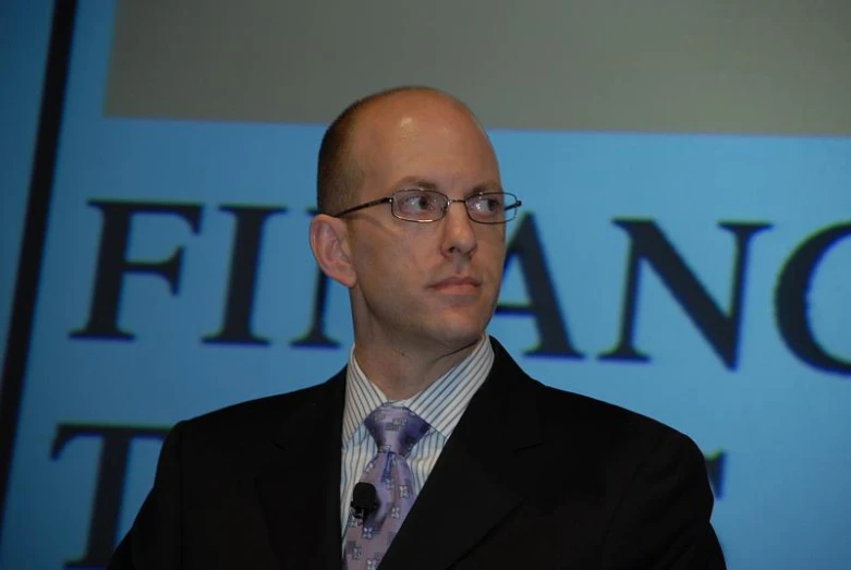 a man in a suit and tie with a microphone