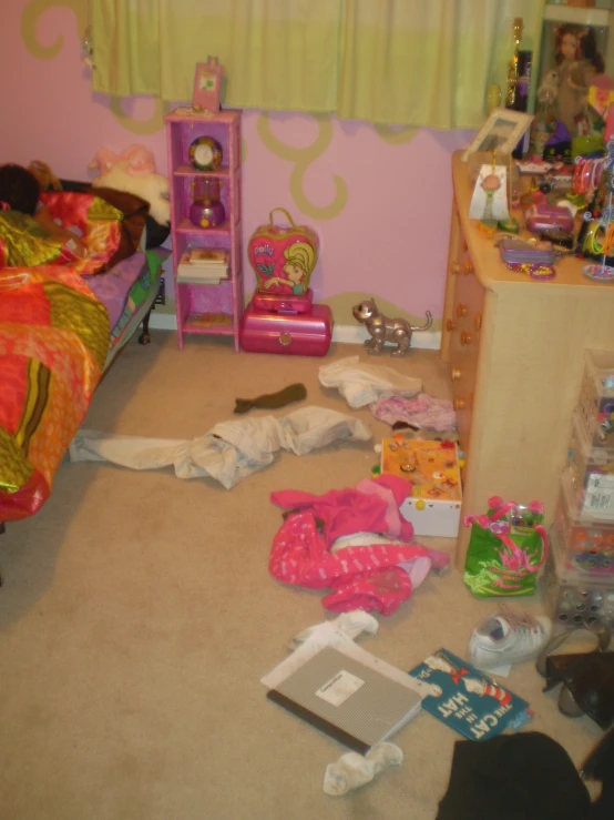 a child's room with pink walls and toys all around