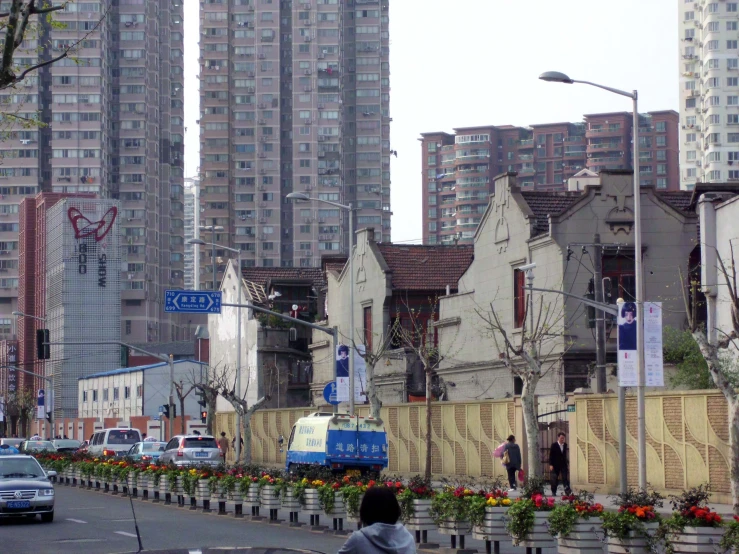 people walking down a city street with tall buildings in the background