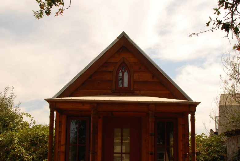 the house is made of wood and has a small wooden front porch